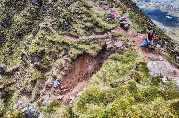 Johny winches stone down the badly eroded gully. Photo © Chris Puddephatt