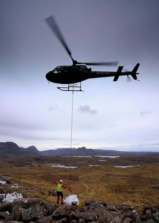 The helicopter lifting a bag of stone from the boulder field. Photo © Chris Goodman.