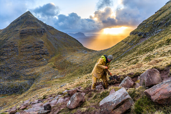 worker laying stone on Quinag path